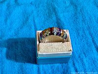 Front view of multi-gemstone sterling silver ring in box