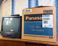TV with screen visible next to original Panasonic box