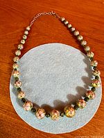 Full view of the necklace showing arrangement of cloisonné and jade beads
