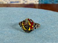 front view of sterling silver ring showing enamel crest and scroll shoulders