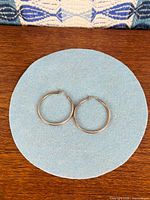 Both hoop earrings on blue background