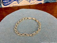 Full view of sterling silver link bracelet laid flat to show chain and clasp