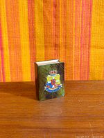 Front view of patinated bronze match holder with Danish coat of arms