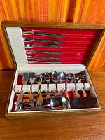 Open case showing full set of knives, forks, spoons, serving pieces and box