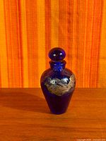 Full view of cobalt blue glass perfume bottle with stopper in place