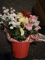 Bucket filled with assorted artificial flowers