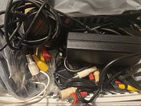 Basket showing tangled black adapter, RCA cables, other leads