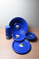 All pieces arranged: large mixing bowl, stack of tumblers, two dinner plates, two small bowls