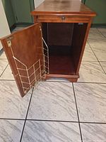 Nightstand door open showing interior compartment and gold-tone wire rack