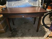 Front view of dark brown veneer desk on tapered legs