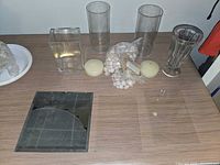 All items displayed on tabletop including vases, mirror panel, pebbles, candles