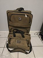 Front view of tall checked suitcase with matching laptop bag attached