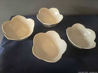 Top view of four porcelain scalloped bowls