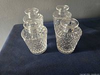 Four clear glass textured jars front view