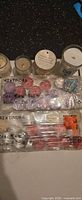 Two sealed 42-packs of IKEA TINDRA tea lights and four used jar candles