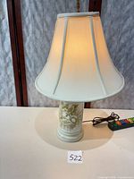 Full view of lamp illuminated showing base design and shade