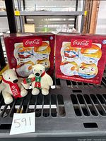 Two boxed plate sets and two plush bears displayed