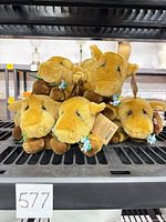 Stack of five golden tan Dakin plush cows with tags visible