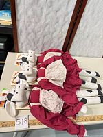 Three Drafty Door Cozy plush cow draft stoppers with tags, ruler showing length