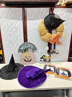 Overall lot showing two velvet hats, two packaged hats, wreath, wooden sign, ghost calendar