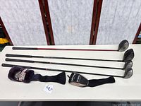 Four left-hand Callaway clubs and two headcovers laid out on table