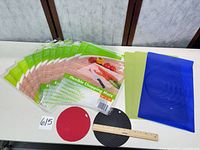 All items laid out: 12 sealed chopping‐mat packs, three loose silicone mats, two round trivets