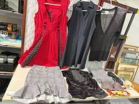 Overview of hanging dresses, sweater, skirt, vest, undergarments and accessories