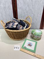 Overall lot: wicker basket holding pillows, ceramic coaster, metal tin