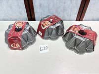 Three identical Nordic Ware Festival Bundt pans with labels