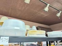 Three stacked tray sets with lids on storage shelf