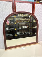 Full view of arched top wall mirror with wood frame