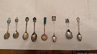 Eight enamel-topped collector teaspoons