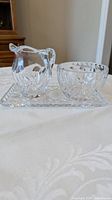 Front view of crystal creamer, sugar bowl, and tray