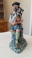 Front view of Royal Doulton “The Piper” figurine showing full design and colours
