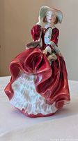 Front view of Royal Doulton Top of the Hill figurine showing red dress and white petticoat