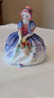 Front view of Royal Doulton Monica figurine showing colors and basket of roses