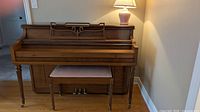 Front view of Mason & Risch upright piano with bench