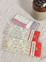 All three ticket stubs displayed on fabric surface, showing front print details