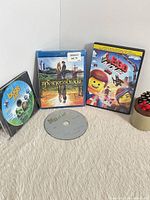 Four discs displayed: A Bug's Life, The Princess Bride in case, The Lego Movie in case, Madagascar disc