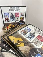 Stack of black record album frames showing packaging insert with guitar image