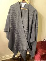 Full view of Marthe Jeffrey wool shawl hanging, showing overall style and fringe