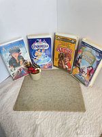 Front view of four VHS tapes standing: Anastasia, Cinderella, Annie, Sleeping Beauty