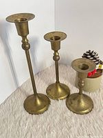 Front view of three brass candlesticks