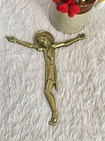 Full view of brass Jesus corpus on fabric background
