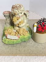 Full view of angel child figurine with adjacent staging item