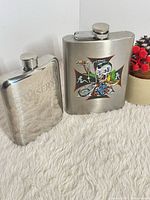 Two stainless steel flasks standing upright