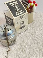 Tea ball with original box on fabric background