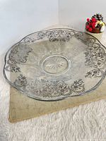 Full view of round glass platter with silver overlay pattern