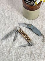 Both knives open on textured surface