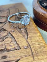 Ring on wooden surface showing top view of stones and band